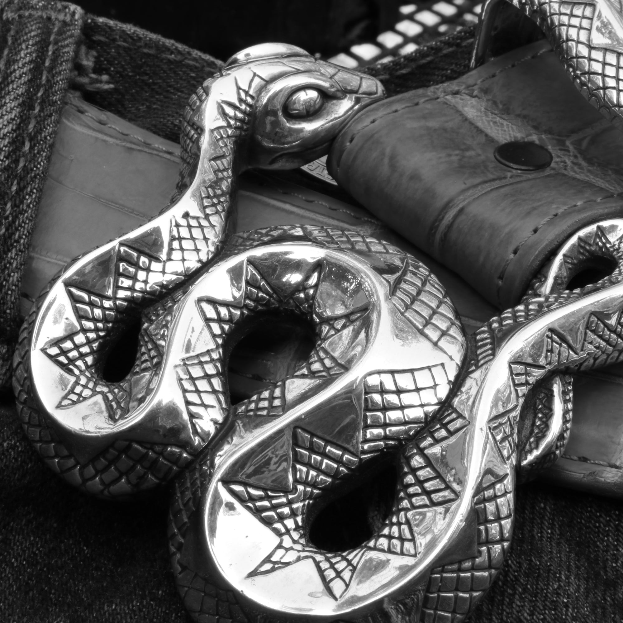 Closeup of the Coiled Snake buckle in Sterling, part of a 3 pc. set that includes a tip and keeper.