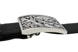The sterling Carved Scroll buckle is shown in side view . The height of the scroll carving is very clear from this angle. Visible also is the swing bar's Skull underneath the black Alligator belt.