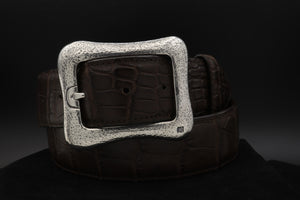 Gently curved free form garrison ,or centre bar buckle, with a vintage, distressed hammered surface.  Shown on a coiled brown alligator belt.