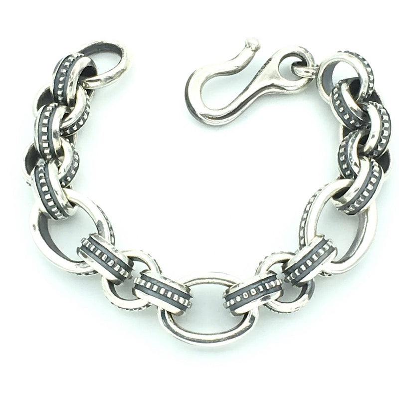 Sterling Chunky Link bracelet comprised of medium sized roud links interspersed with 3 larger oval links.  Both sizes feature centre ridge design of raised "Dots". Hook and ring closure. 