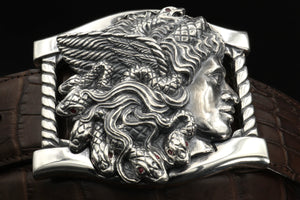 Sterling buckle Medusa head with Ruby eyed snakes, carved as a side view. Each writhing snake in her hair has rubies for eyes. It sits on a base frame accented with twist detail. Shown on a brown alligator belt.