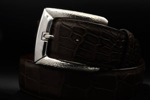 Image of #1393 sterling harness buckle on a coiled strap with a dark background.