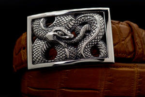 Dramatic closeup front view of the Sterling Ouroboros Rectangular Frame buckle on a coiled tan alligator belt.