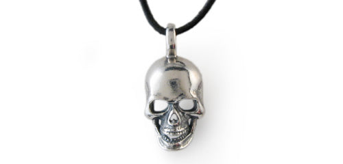 Small Sterling Skull hangs from thin black leather cord. Found in the Pendant Collection.