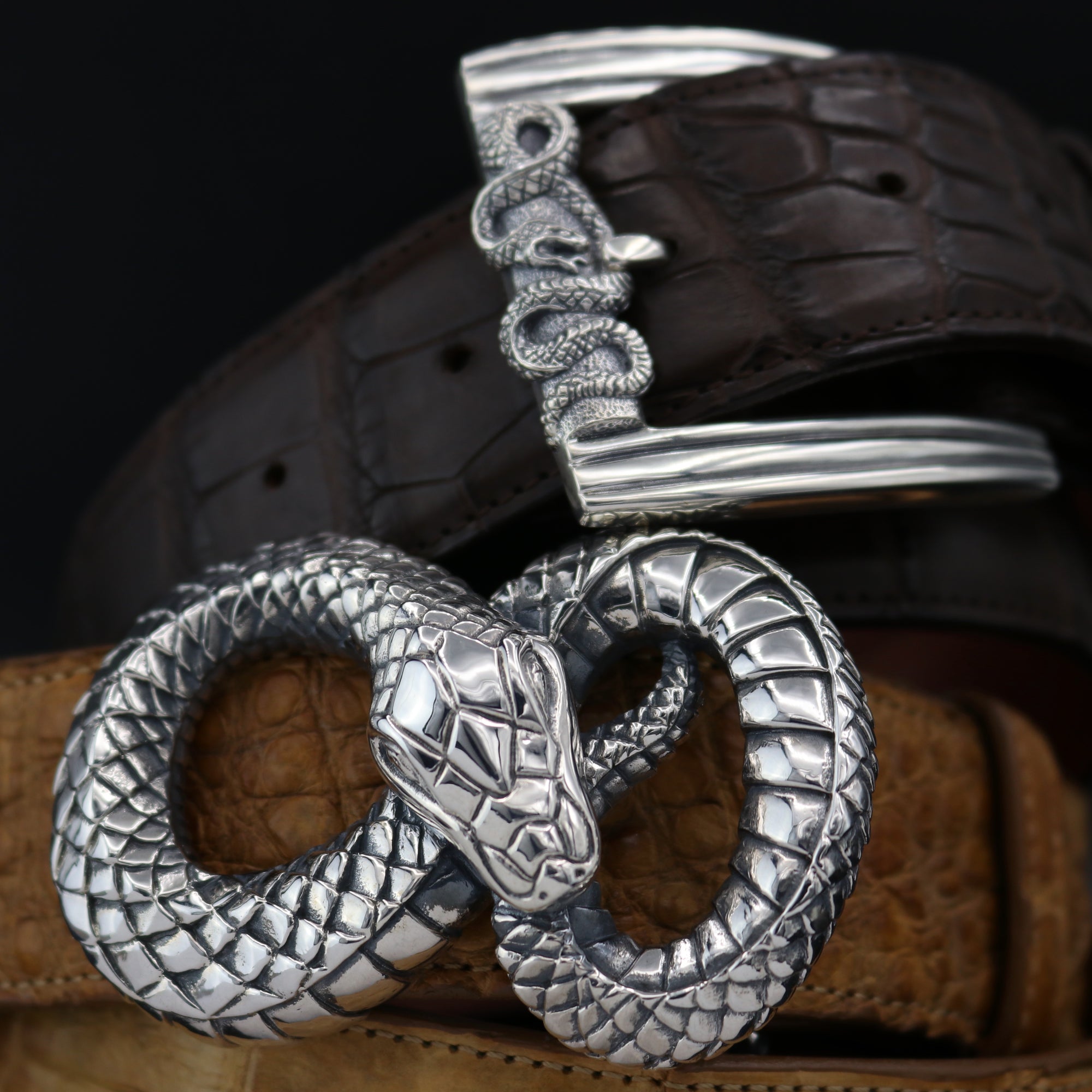 Two Sterlin Silver Snake buckles, for men or women. The top buckle has a Snake wrapping the front of the rectangular harness buckle. The bottom buckle is of a  Figure 8 shape. These both fit 1.5" belts.