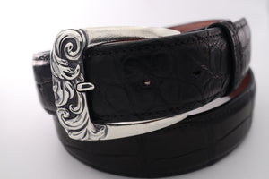 Classic Sterling harness style buckle with deep carved scroll design on front. Top view. Shown on a coiled black alligator belt.