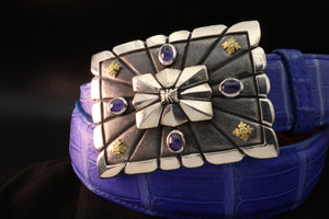 Sterling scalloped edge rectangular buckle with ribbed centre shield, features 4 bezel set tanzanite cabs and 18kt accents in each corner. Shown from an angled view on bright blue alligator strap.