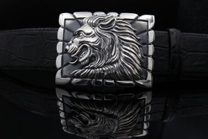 Sterling belt buckle on belt strap. Heraldic style Lion's head in profile. Sculpted in high relief atop a rectangular trophy buckle base that is textured with polished edging.  