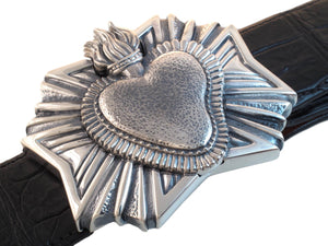 Angled view from above of the sterling Heart Milagro buckle on a black Alligator strap.