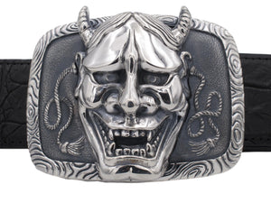 Front on view of the Sterling Hanya Mask Trophy buckle featuring the high relief sculpting of the mask set on a decorated and antiqued base.
